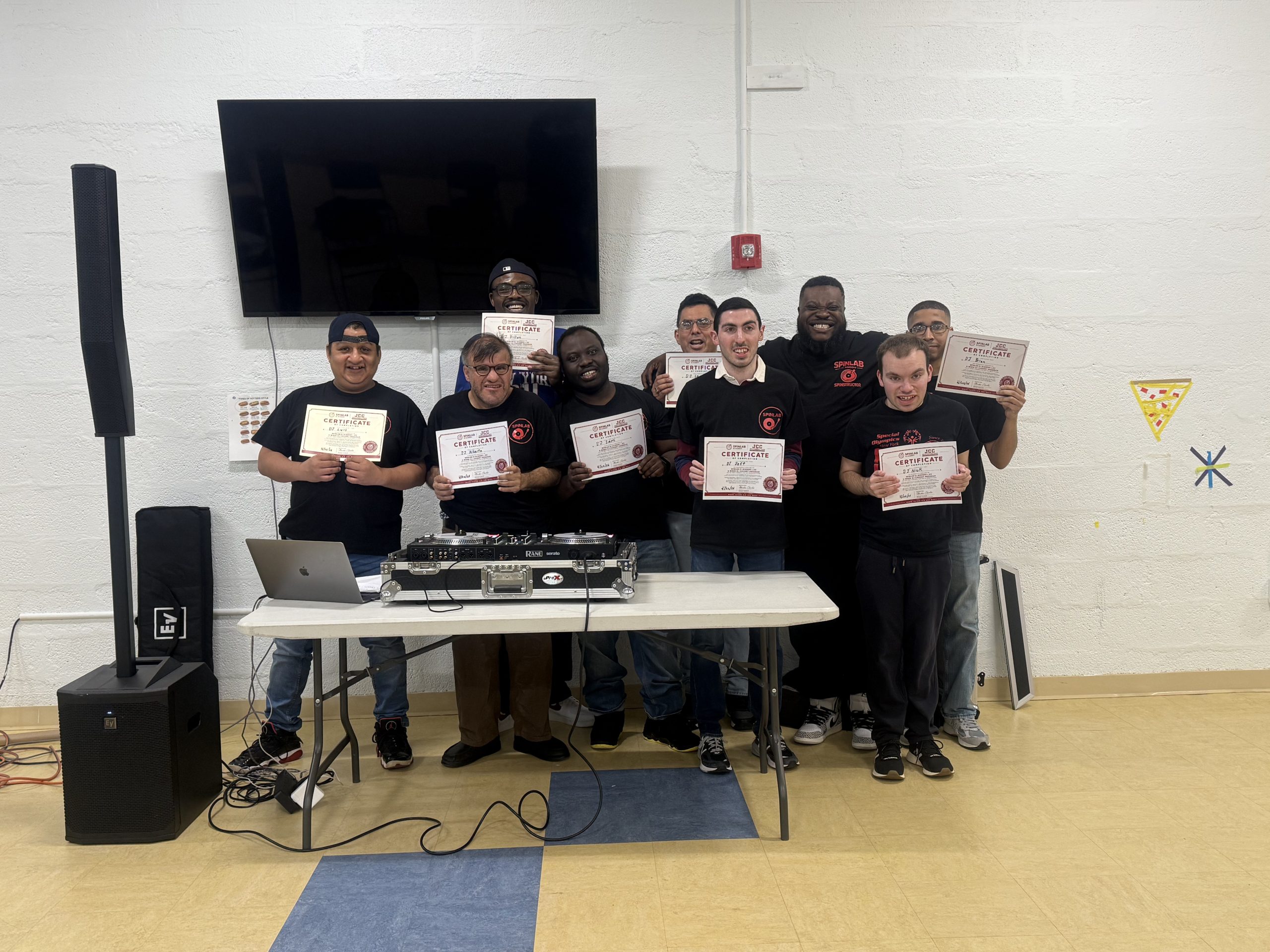 SpinLab students holding certificates after completing a DJ program