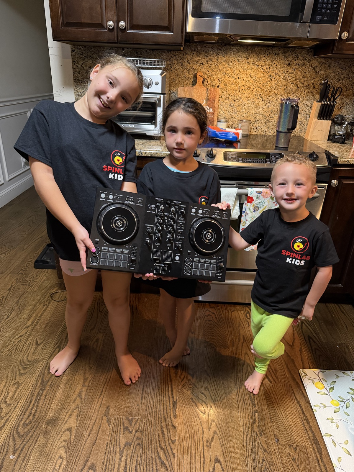 Three SpinLab Kids students holding a controller after a lesson