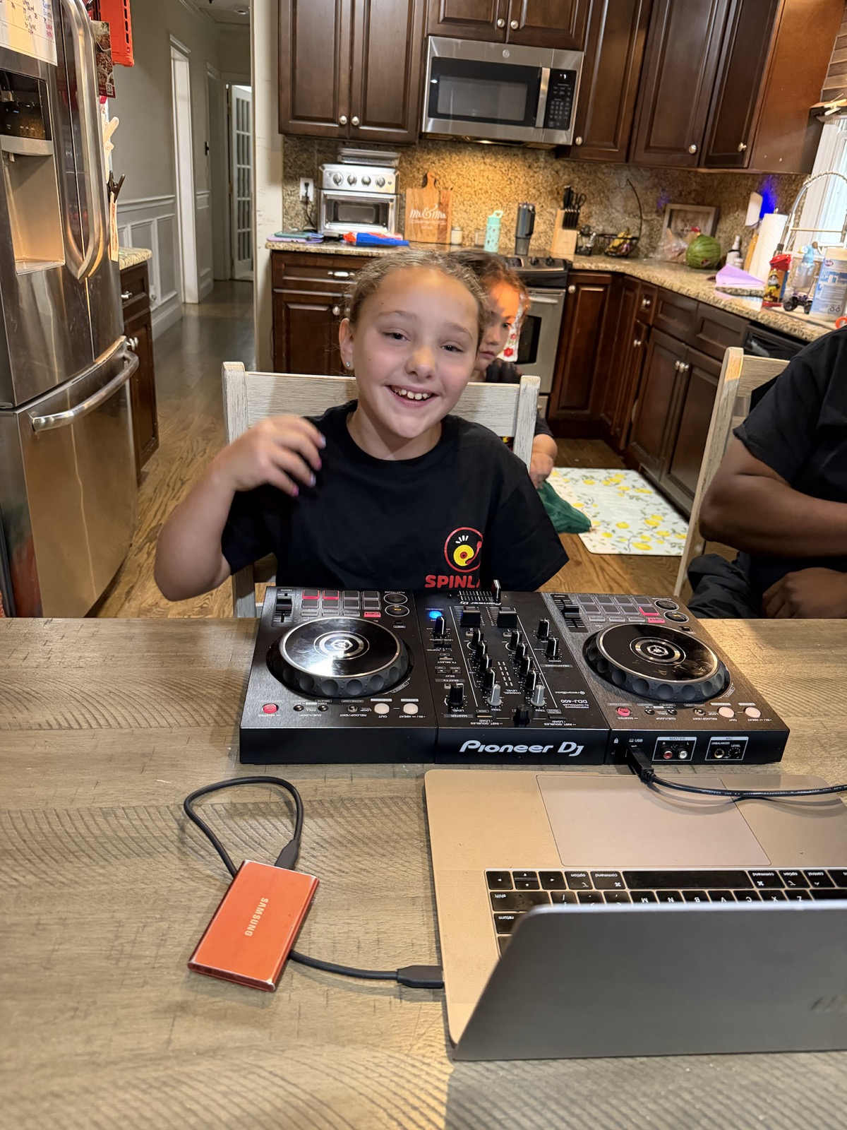 Young student smiling behind a DJ controller